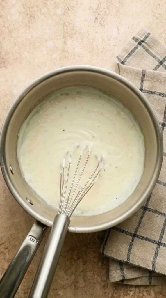 Béchamel Sauce (Classic White Sauce) Bechamel sauce in pot with whisk.