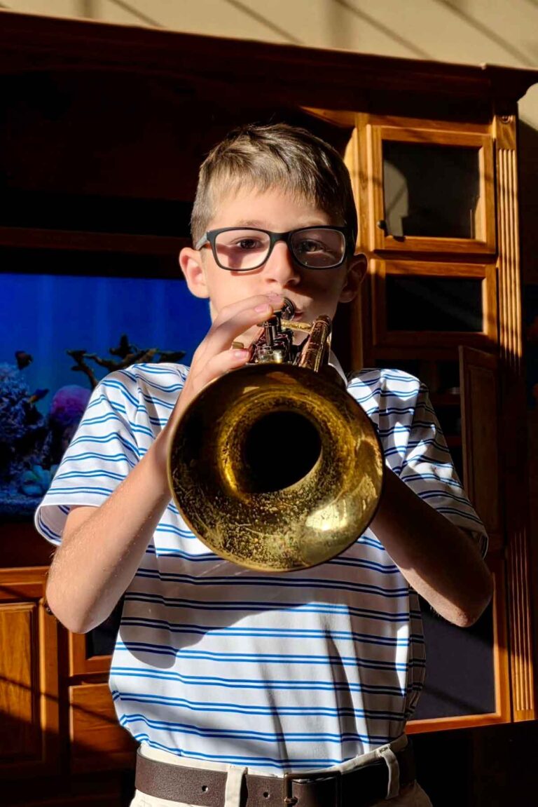 Friday Things #595 – Brown Eyed Baker Boy with glasses playing the trumpet.